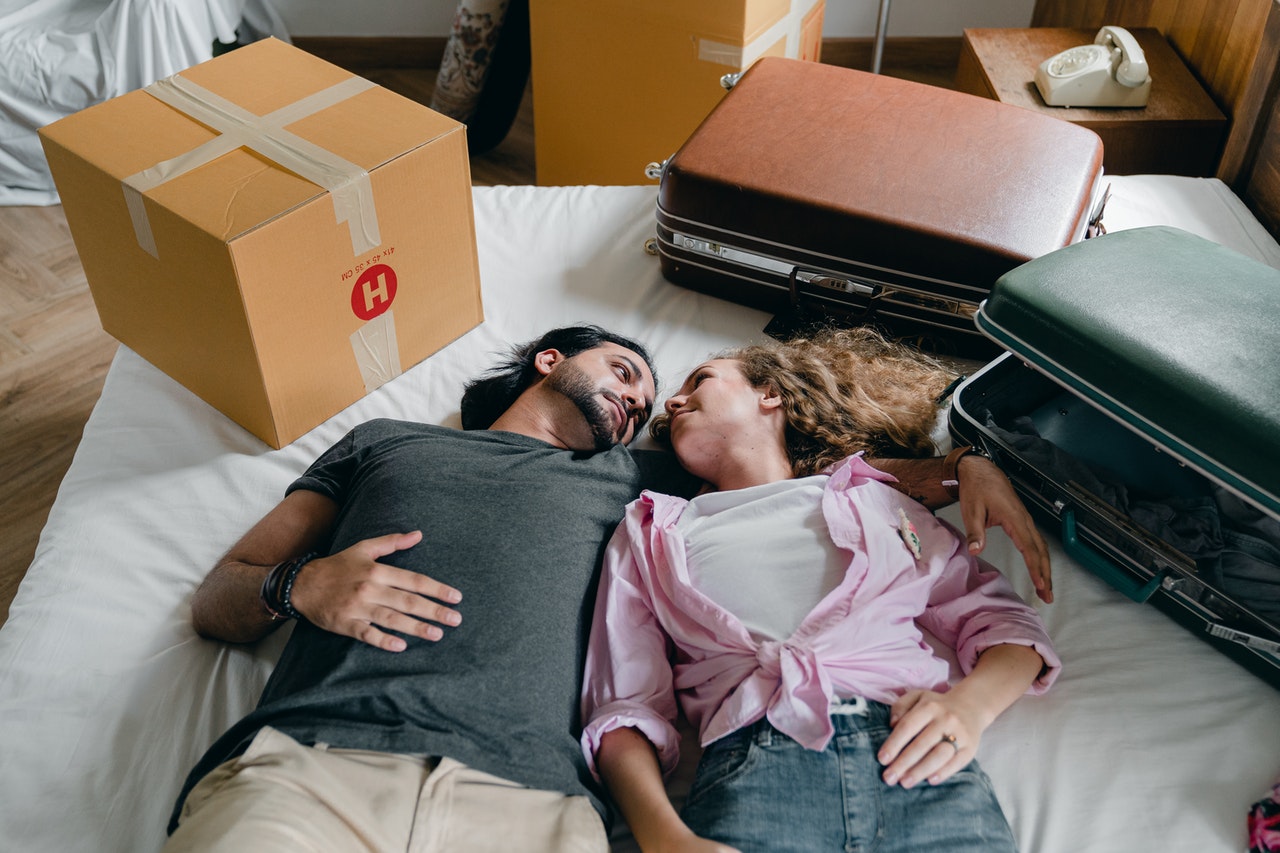 Couple relaxing on bed in their new home
